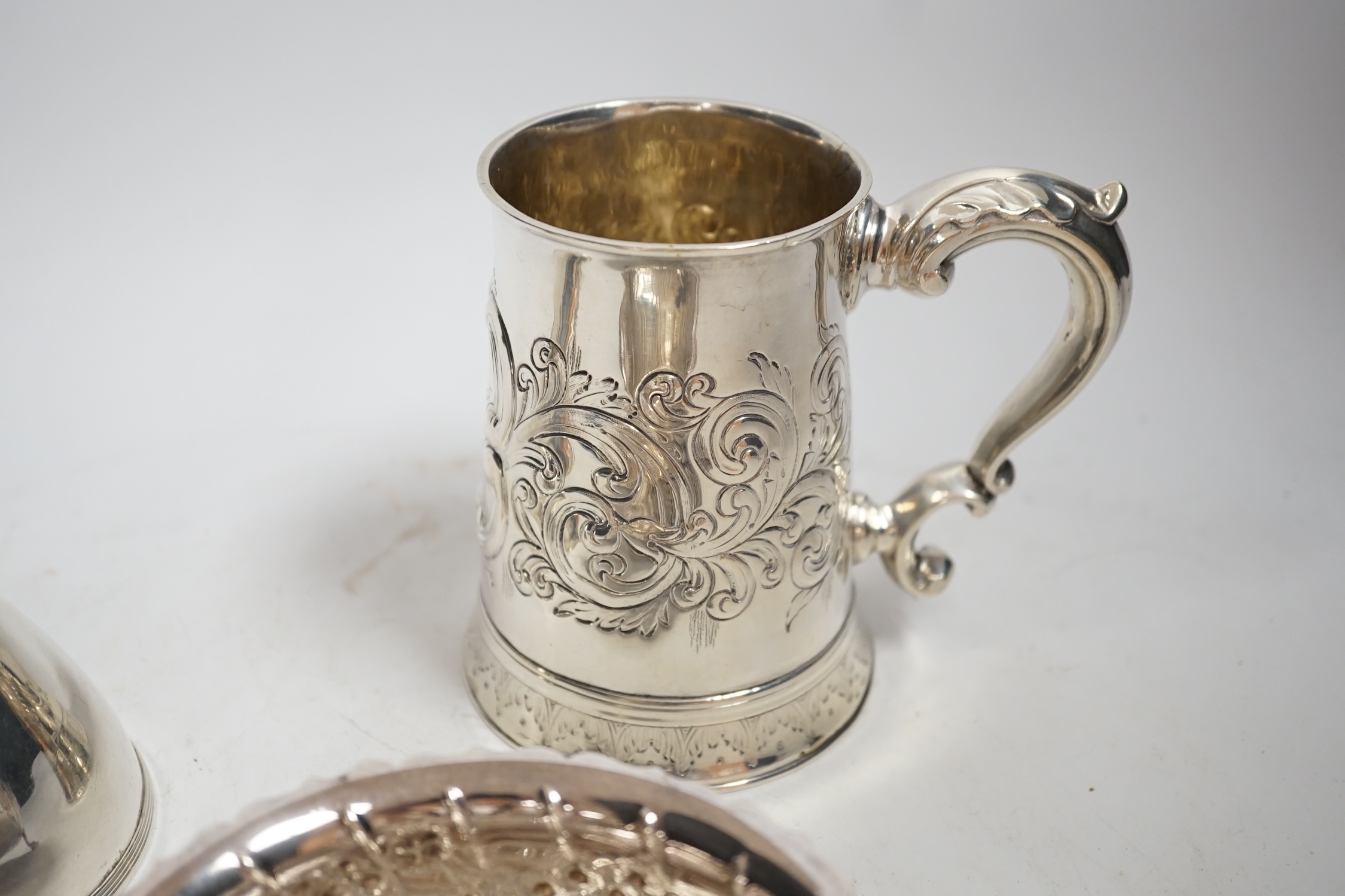 A George III silver mug, with later embossed decoration, London, 1783,11.6cm, together with a George III silver wine funnel and a modern Irish silver sugar bowl, 21.5oz.